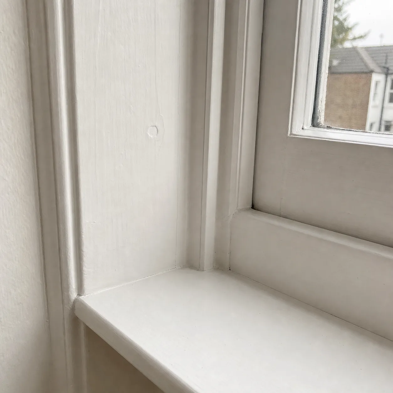 A spotless white light switch beside a painted door frame, wiped to inspection standard